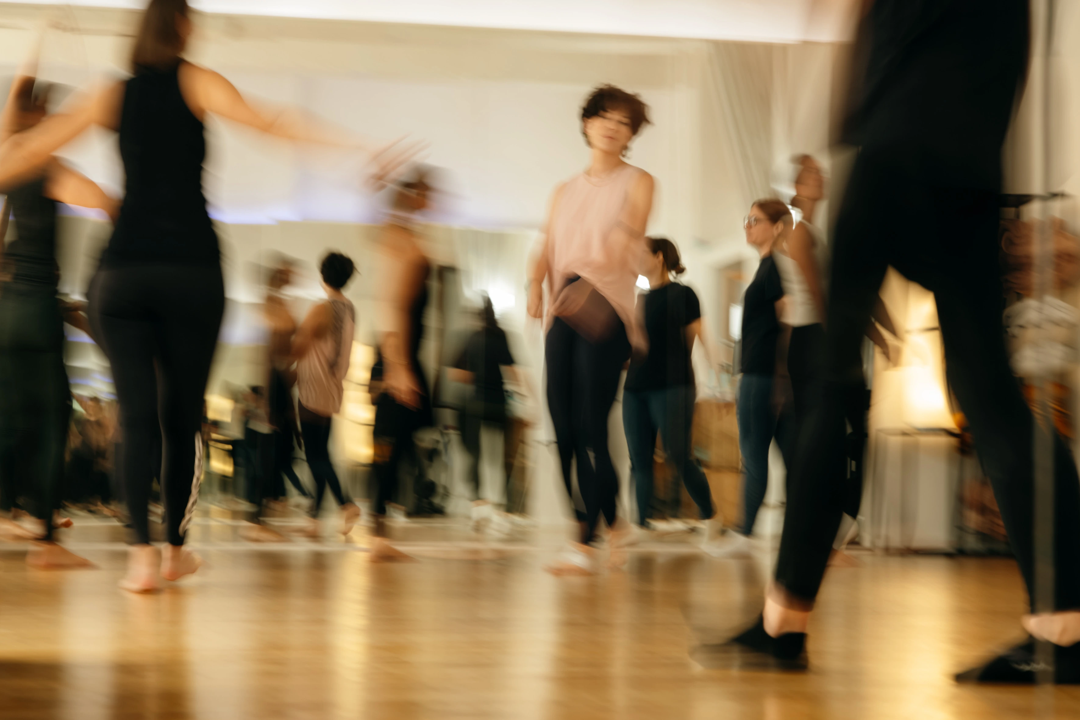 Les participantes dansent ensemble dans le studio, photographiées en mouvement.